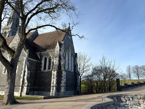 Historic Copenhagen Church Architecture: A traditional Danish church building featuring dark stone walls accented with white painted cornerstones and window trim beneath a classic shingled roof design