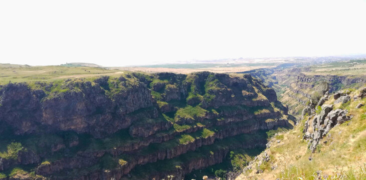 Rugged Rock Cliff Face with Green Vegetation, view from the top of the mountain lori canyon, Armenia