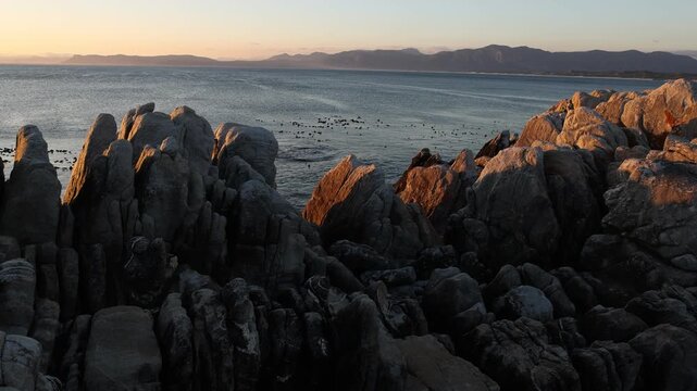 Rocky coastline, DeKelders,  South  Africa, overlooking Walker Bay Nature Reserve and Klein Mountains