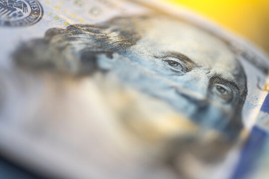 Extreme macro close-up of Benjamin Franklin's portrait on a US 100 dollar bill. Detailed engraving of American currency, showing texture and intricate ink patterns for finance and economy concepts.