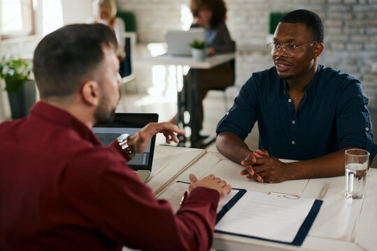 Recruitment professional interviewing young african man in office