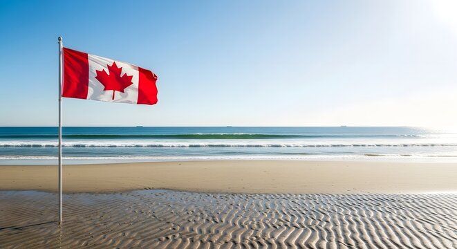 Vibrant Canadian flag waves on a sunny beach during Canada Day celebrations with ocean waves and sandy shore.