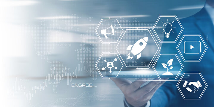 Businessman holding a tablet displaying a futuristic interface with startup and marketing icons representing digital innovation and growth strategies