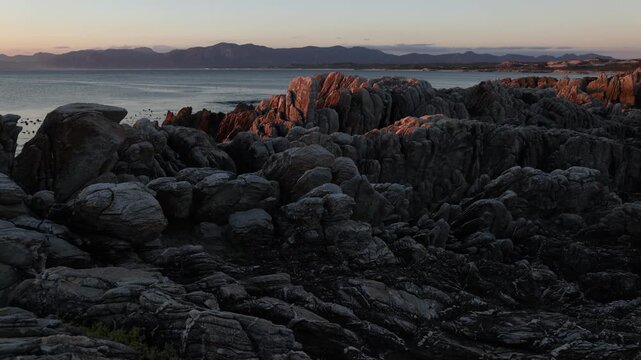 Rocky coastline, DeKelders,  South  Africa, overlooking Walker Bay Nature Reserve and Klein Mountains