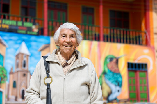 Happy senior lifestyle concept. Senior woman at the central square of the beautiful small town of Raquira. The city of pots in Colombia.
