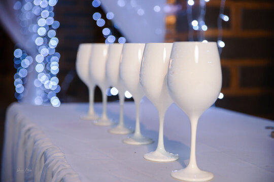 Elegant glassware arrangement with wine glasses aligned on a decorated table, creating a refined and sophisticated ambiance.
