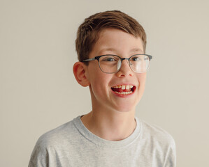 Fototapeta premium Smiling boy portrait with glasses isolated on white background studio close up
