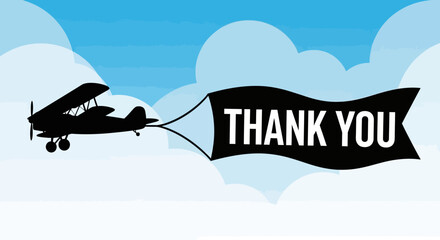 Biplane flying across blue sky pulling a thank you banner. © Joko