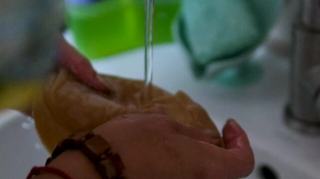 Series shows a woman preparing kombucha in a rural Ukrainian home. She rinses the tea mushroom, cleans jars, pours fermented drink into bottles, highlighting traditional lifestyle and health benefits.