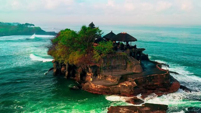 Breathtaking aerial view of of Tanah Lot Temple. Tanah Lot is a rock formation off the Indonesian island of Bali. It's home to the pilgrimage temple Pura Tanah Lot, a popular tourist and cultural icon