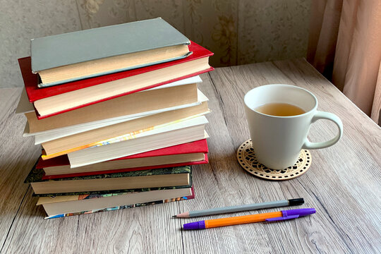 A stack of books and a cup of tea on the table. Concept of studying, teaching, reading, learning and for backgrounds.