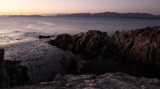 Rocky coastline, DeKelders,  South  Africa, overlooking Walker Bay Nature Reserve and Klein Mountains