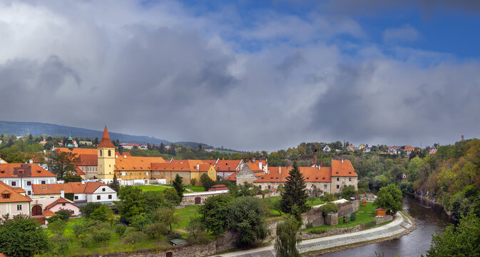 Minorite Monastery view across Vltava river in Cesky Krumlov, Czechia. Medieval religious architecture under cloudy sky
