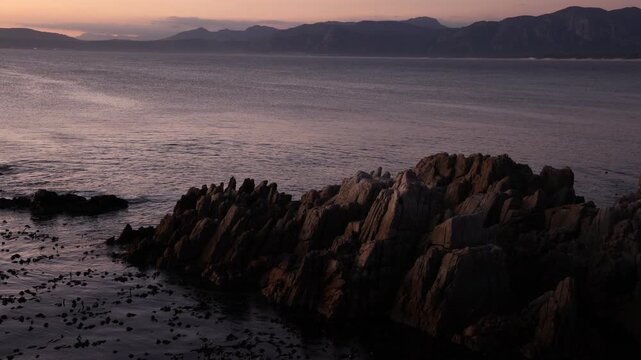 Rocky coastline, DeKelders,  South  Africa, overlooking Walker Bay Nature Reserve and Klein Mountains