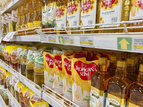 Depok, Indonesia - March 31, 2026: A variety of cooking oil products, including palm oil and corn oil from prominent Indonesian brands Tropicana Slim, Sania, and Fortune, are displayed on a retail ais