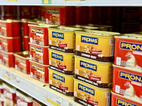 Depok, Indonesia - March 31, 2026: A variety of Pronas brand canned corned beef and chicken products neatly arranged on a retail aisle rack at Tip Top Supermarket in Depok. 