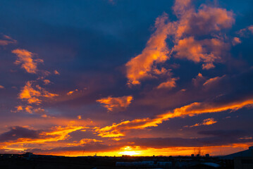 Obraz premium Colorful sunset sky in Iceland with glowing orange and purple clouds. Beautiful Iceland nature scene with dramatic light, vibrant colors, and peaceful evening atmosphere.