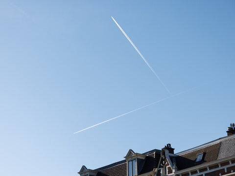 Two trails of planes in the sky make an almost perfect 90 degree angle from each other.