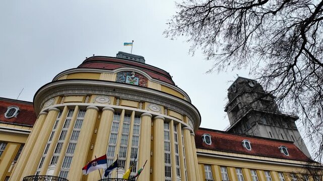 Historic city hall with clock tower and surrounding architecture in Senta Serbia under cloudy sky, highlighting urban heritage, administration and European cityscape