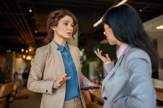 Businesswomen talking collaborating and discussing ideas in office