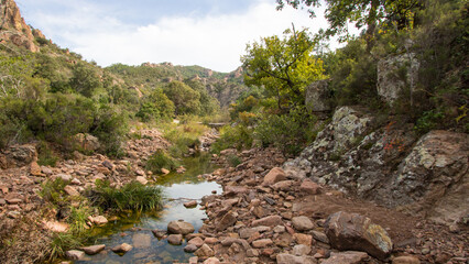 Paysage sauvage du Massif de l'Estérel : rivière claire entre roches rouges et végétation méditerranéenne © jef 77