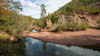 Paysage sauvage du Massif de l'Estérel : rivière claire entre roches rouges et végétation méditerranéenne © jef 77