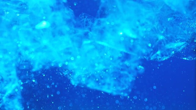 Ice cubes falling into water with oxygen bubbles, frost patterns, and soft light reflections. Concepts for beauty advertising, menu designs for bars and restaurants, cryotherapy.