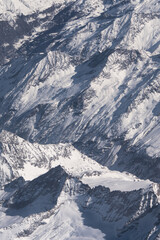 Naklejka premium Panoramic view of the snowy Alps mountains from above, View of the snowy Alps mountains from the airplane window