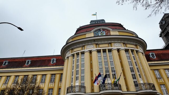 Historic city hall with clock tower and surrounding architecture in Senta Serbia under cloudy sky, highlighting urban heritage, administration and European cityscape