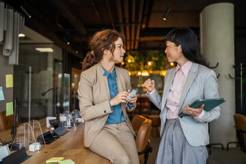 Business women collaborating and discussing work in modern office