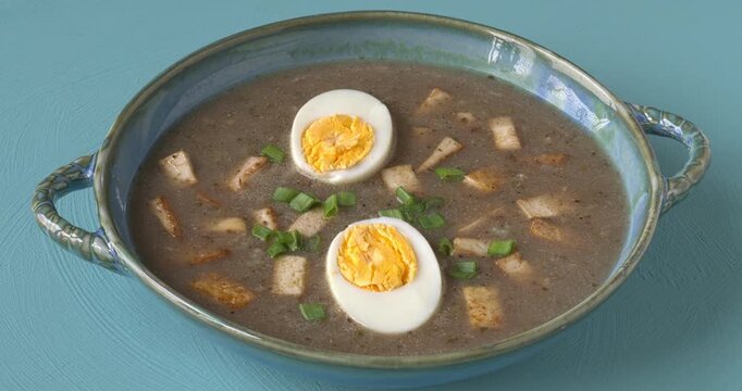 Vegetarian version of sour rye soup with tofu and hard-boiled eggs - blue background.