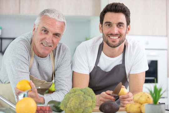 son with his senior father cooking in the kitchen