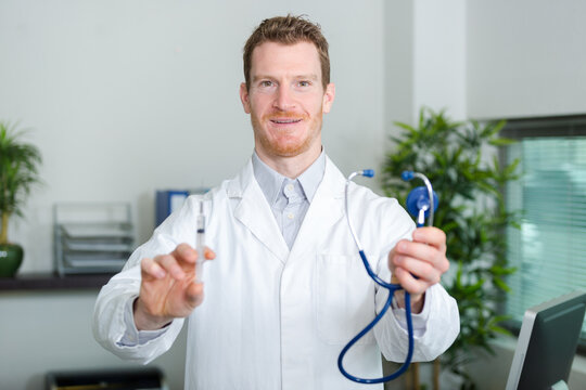 male doctor holding syringe with injection