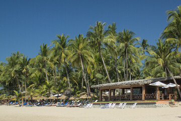 Fototapeta premium Tropical beach resort with palm trees and sandy beach in Ngapali Myanmar, Southeast Asia
