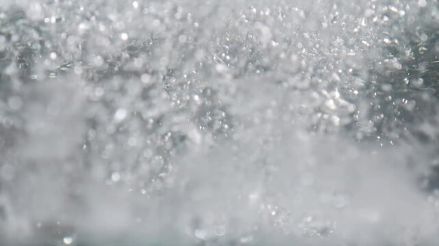 Ice cubes falling into water with oxygen bubbles, frost patterns, and soft light reflections. Concepts for beauty advertising, menu designs for bars and restaurants, cryotherapy.