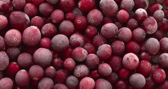 Raw, frozen cranberries as a food background texture. Table spin.