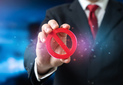An official holds a prohibition sign introducing new restrictions and rules. Regulatory changes affect business decisions. Guidance highlights compliance, risk avoidance in evolving legal frameworks.