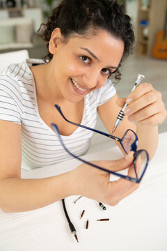 young female technician repairing glasses