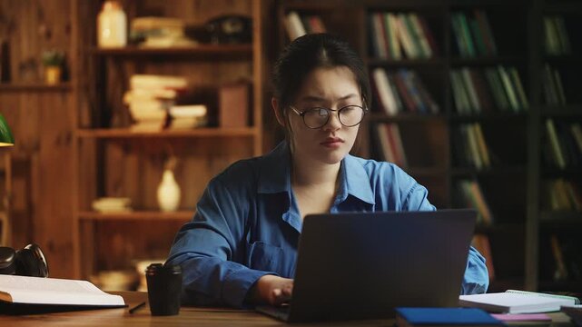 Young Asian female reading bad news email on laptop, unhappy with failed exam