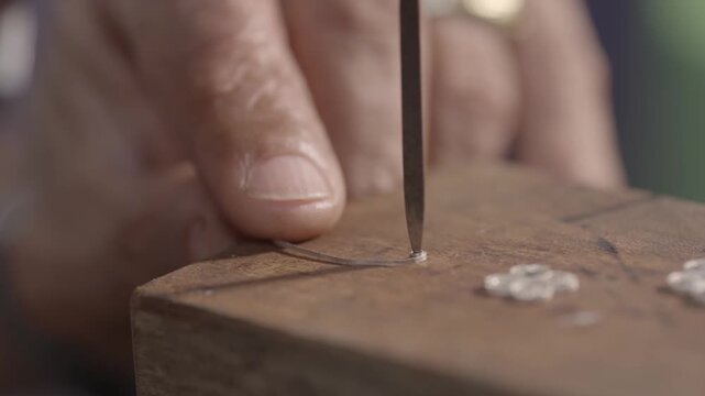 Hand guides a tool with care over wood. Finger steadies object. Focus on precision. Craftsman shapes material. Ideal for close-up work scenes
