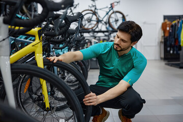 Skilled male technician thoroughly inspects bicycle wheel quality © Nomad_Soul