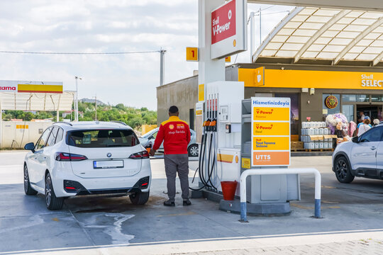 Nevsehir, Turkey - September 18, 2025: White BMW SUV refuels at Shell gas station with attendant in red uniform and convenience store visible in the background