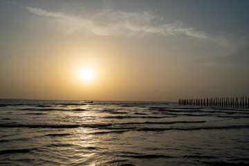 Obraz premium Sunset over ocean with boat silhouette at Kaefunk Beach Zanzibar