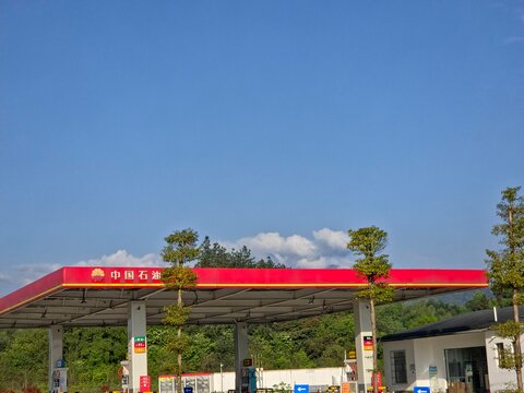 PetroChina gas station with a red canopy against a clear blue sky and green trees on March 27, 2026 in Sichuan Province, China.