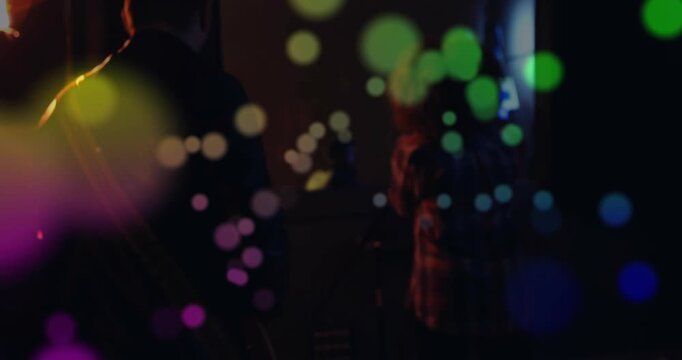 Vocalist singing into mic during music rehearsal, camera pulling back while bokeh hiding faces