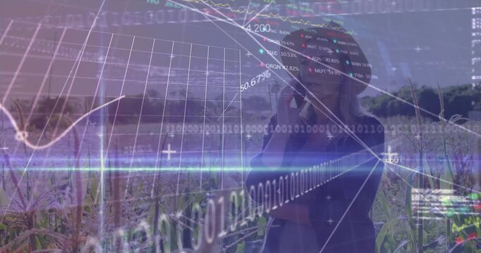 Woman standing in crop field holding phone, call initiating evolving data HUD for crop monitoring
