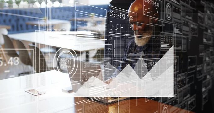 Mature manager typing on laptop in office, initiating animated charts analyzing business metrics