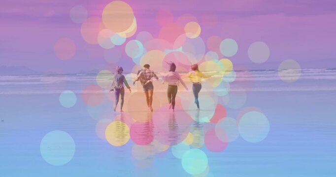 At scene start women dancing linking and walking to horizon with bokeh over wet sand