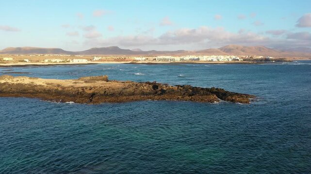 Aerial view of rough Atlantic waves in Fuerteventura ending with El Cotillo coastal village