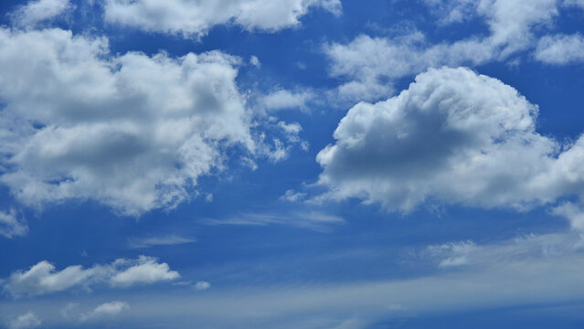 Water cycle and meteorology: cumulus and altocumulus clouds against a blue spring sky.